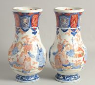A PAIR OF JAPANESE IMARI PORCELAIN VASES, each painted with figures in an outdoor setting with