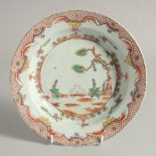 A CHINESE EXPORT PORCELAIN SOUP DISH, painted with pecking birds in a floral border, 23cm diameter.