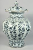 A VERY LARGE CHINESE BLUE AND WHITE PORCELAIN URN AND COVER, painted with various panels of native