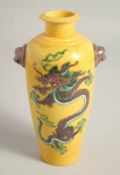 A CHINESE YELLOW GROUND TWIN HANDLE VASE, painted with a dragon to each side with moulded lion dog