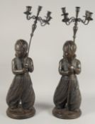 A LARGE PAIR OF FIGURAL BRONZE CANDELABRA, each with a standing Nubian figure holding a staff with
