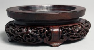 A CHINESE CARVED AND PIERCED OVAL SHAPE HARDWOOD STAND, 15cm wide.