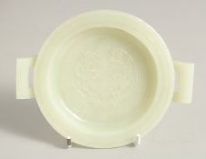 A CHINESE CARVED JADE TWIN HANDLE DISH, with carved central beast motif, 14cm handle to handle.