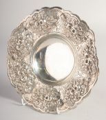 A DECORATIVE WHITE METAL CIRCULAR BOWL, with moulded and repousse decoration, raised on three