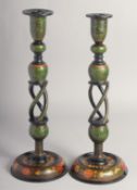 A PAIR OF EARLY 20TH CENTURY INDIAN KASHMIRI LACQUERED CANDLESTICKS, painted with flora. 37.5cm