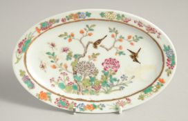 A SMALL CHINESE FAMILLE ROSE PORCELAIN OVAL DISH, painted with birds and native flora, six-character