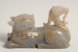 A CHINESE CARVED HARDSTONE FIGURE of a reclining beast, with painted gilt highlights, 7cm long.