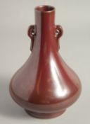 A CHINESE MOTTLED OX BLOOD GLAZE TWIN HANDLE VASE, with impressed mark to base, 22cm high.