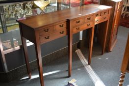 A mahogany breakfront side table with numerous small drawers and long drawers on tapering square