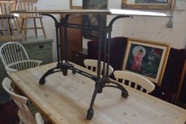 An unusual rectangular table, the zinc and oak top supported on a cast iron base.