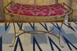 A wrought iron stool with gilded decoration.
