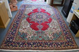 A Persian style carpet, red ground with floral decoration, 305cms x 210cms.