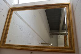 A gilt framed rectangular wall mirror.