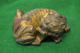 A Chinese gilded metal model of a recumbent lion.
