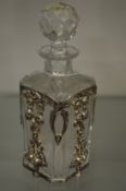 A silver mounted cut-glass small decanter.