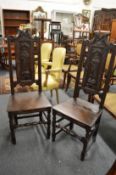 A pair of carved oak high back hall chairs.
