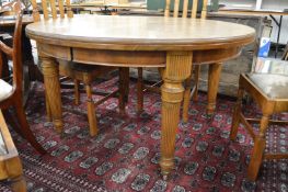 An oak circular extending dining table (no extra leaves or winding handle).