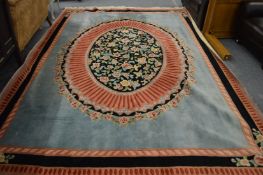 A large French design carpet, turquoise ground with central oval background panel decorated with