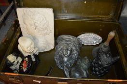 A trunk containing decorative items to include an old hand bell, door stop etc.