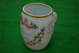 A small enamelled opaque glass tankard.