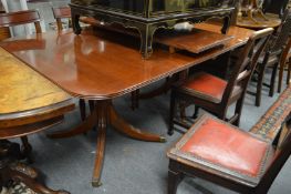 A mahogany twin pedestal extending dining table with one leaf.