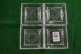 A set of four small glass dishes.