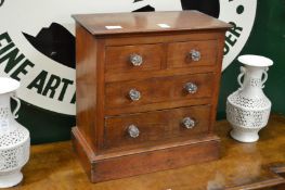 A table top mahogany chest of drawers.