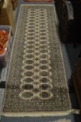 A modern beige ground Bokhara style runner, 240cms x 78cms.