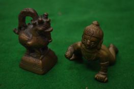 A small bronze baby Krishna and a scroll weight.