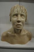 An unusual cream pottery bust of a youth.