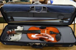 A cased violin with accessories.