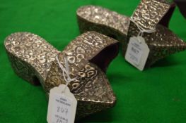 An unusual pair of white metal clogs / shoes.