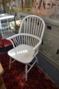 A pair of cream painted Windsor style armchairs, together with four painted kitchen chairs.