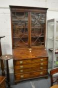 A George III mahogany bureau with associated bookcase top.