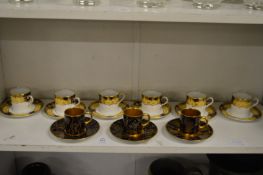 A set of six Aynsley coffee cans and saucers and three gilt decorated coffee cans and saucers.