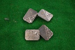 A pair of silver cufflinks.