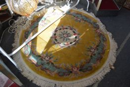 A Chinese circular rug, gold ground with floral decoration, 106cms diameter.