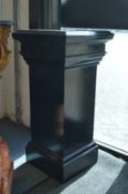 An ebonised pedestal stand.