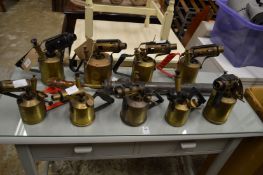 A quantity of old blow torches and a pesticide sprayer.