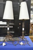 A pair of metal tripod table lamps.