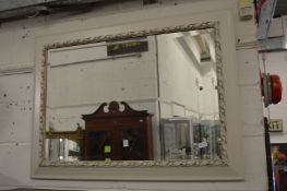 A rectangular wall mirror with decoratively painted frame.