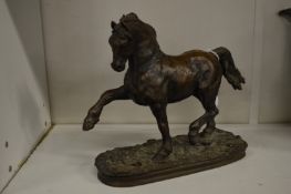 A bronzed model of a prancing horse.