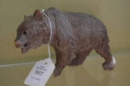 A carved wood model of a bear.