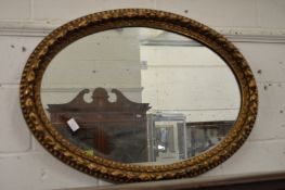 An oval gilt framed mirror.