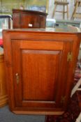An oak hanging corner cupboard.