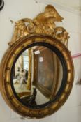 A Regency giltwood convex mirror with eagle cresting.