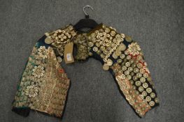 An Armenian child's vest or cape with applied embossed metal and shell decoration.