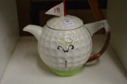 A Tony Wood novelty teapot in the form of a golf ball and putter.