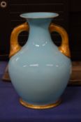 A blue and gilt twin handled vase.