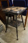 A two tier table with cast metal claw and ball feet.